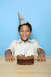 Boy posing in front of his birthday cake