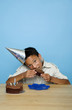 Boy with party hat eating cake