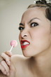 An angry young adult holding a lollipop