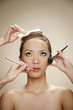 Hands making-up woman's face