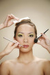 Hands making-up woman's face