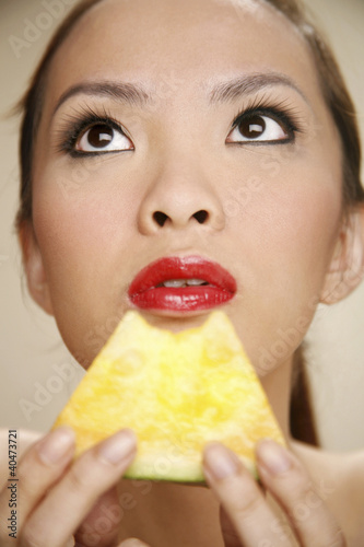Photo: Young woman with a slice of yellow water-melon Young woman with a slice of yellow water-melon