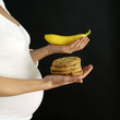 Pregnant woman with cookies and banana