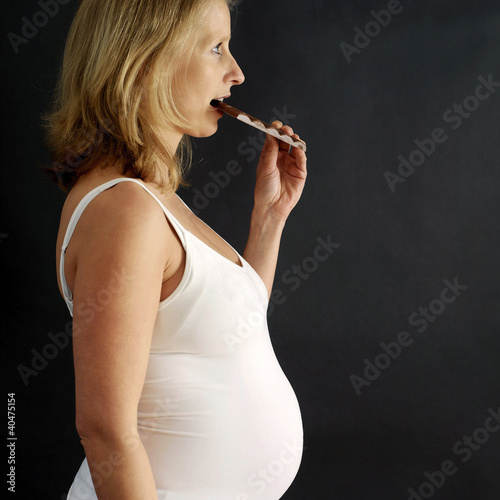 Photo: Pregnant woman eating chocolate bar Pregnant woman eating chocolate bar