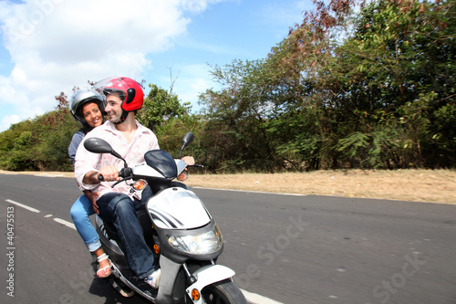 Foto: Couple riding motorbike on a country road Couple riding motorbike on a country road