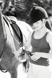 Girl adjusting the saddle on her horse