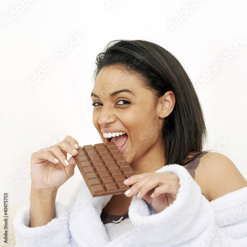 Photo: Woman in bathrobe enjoying a bar of chocolate Woman in bathrobe enjoying a bar of chocolate