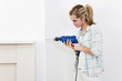 Woman drilling the wall