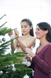 Mother and daughter decorating the Christmas tree 