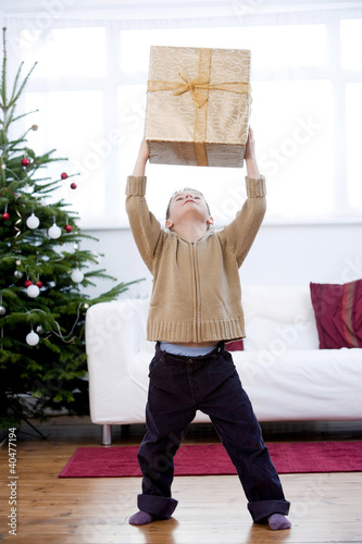Foto: Little boy lifting a present Little boy lifting a present