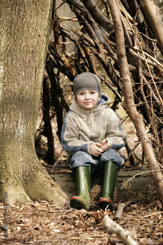 Photo: Boy sitting on tree trunk Boy sitting on tree trunk