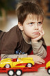 Little boy playing with a yellow car