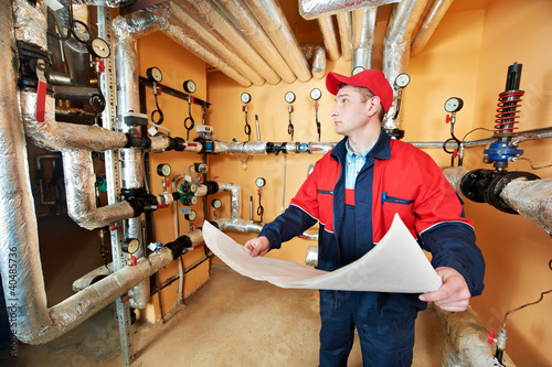 Photo: heating engineer repairman in boiler room heating engineer repairman in boiler room