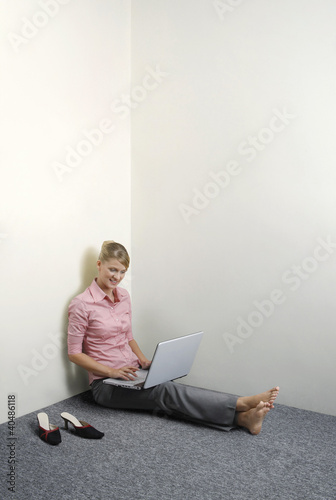 Photo: Businesswoman sitting on the floor using laptop Businesswoman sitting on the floor using laptop