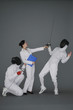 Businesswoman protecting a man by holding a gun at his opponent