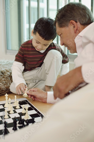 Photo: Man playing chess game with boy Man playing chess game with boy