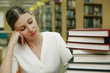 Woman staring at a stack of books in the library