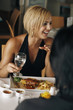 Woman holding a glass of water laughing while looking away