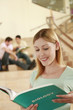 Woman holding a book with two men discussing in the background