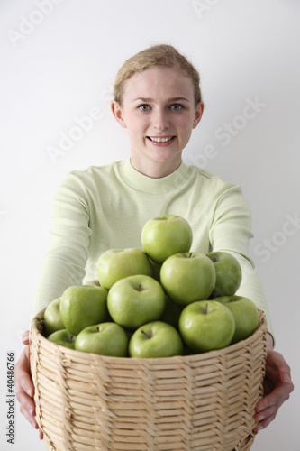 Photo: Woman with a basket of green apples Woman with a basket of green apples