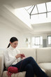 Woman sitting on couch knitting