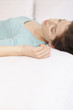 Woman lying in bed with her eyes closed