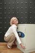 Businesswoman trying to lift safe