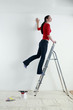 Woman standing on ladder