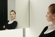 Woman in formal wear looking at her reflection in the mirror