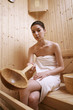 Woman holding wooden sauna ladle