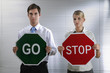 Foto: Businessman with a 'Go' sign, businesswoman with a 'Stop' sign Businessman with a 'Go' sign, businesswoman with a 'Stop' sign