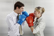 Foto: Businessman and businesswoman with boxing gloves facing each other Businessman and businesswoman with boxing gloves facing each other