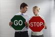 Foto: Businessman with a 'Go' sign and businesswoman with a 'Stop' sign screaming at each other Businessman with a 'Go' sign and businesswoman with a 'Stop' sign screaming at each other