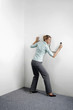 Foto: Businesswoman examining wall with the stethoscope Businesswoman examining wall with the stethoscope