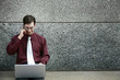Photo: Businessman talking on the phone while using laptop Businessman talking on the phone while using laptop