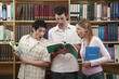 Two men and a woman looking shocked in the library
