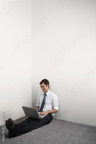 Photo: Businessman sitting on the floor using laptop Businessman sitting on the floor using laptop