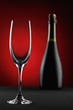 Champagne glass with a bottle of champagne in the background