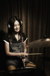 Young woman with headphones playing drums