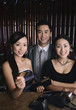 Woman showing credit card with her friends beside her
