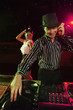 Man spinning some tunes on turntable with woman dancing in the background