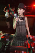 Woman spinning turntable while singing with people dancing in the background
