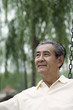 Foto: Senior man contemplating while sitting on a swing Senior man contemplating while sitting on a swing