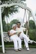 Foto: Senior woman sharing a book while sitting on a swing Senior woman sharing a book while sitting on a swing