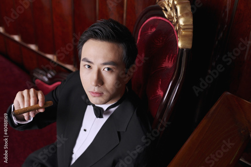 Photo: Man in tuxedo holding a cigar Man in tuxedo holding a cigar