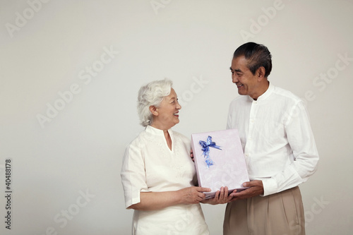 Photo: Senior woman receiving gift from senior man Senior woman receiving gift from senior man