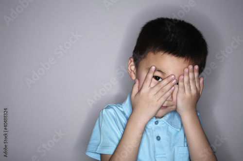 Photo: Boy peeping through his fingers Boy peeping through his fingers