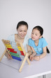 Woman teaching girl how to use the abacus