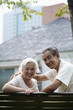 Foto: Senior couple smiling at the camera while sitting on a swing Senior couple smiling at the camera while sitting on a swing