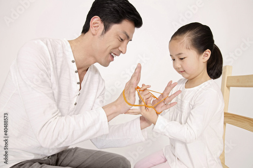 Photo: Man showing girl some rubber band tricks Man showing girl some rubber band tricks